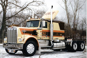 一輛復古Kenworth半掛卡車停在白雪覆蓋的樹林區域。 — 老福特卡車 壁紙