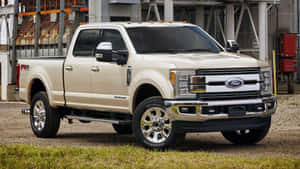奶油色福特F-150 FX4皮卡車停在工業建築附近的礫石上。 — 1600x900 壁紙