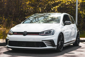 白色 Volkswagen Golf GTI 在陽光明媚的日子停放在戶外。 — 福斯汽車 壁紙