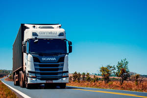 白色 Scania 卡車在晴朗藍天下行駛在鄉村高速公路上。 — 卡車 壁紙
