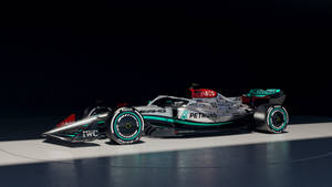 一輛帶有Petronas品牌的銀色和藍綠色一級方程式賽車，在工作室燈光下。 — 暗黑美學電腦 壁紙