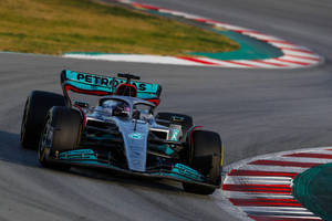 Mercedes F1賽車在日落時分的賽道上奔馳。 — 銀色 壁紙