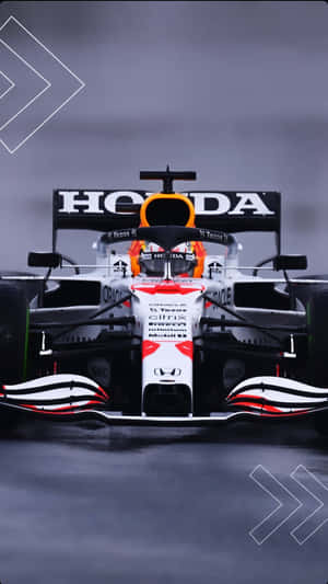 帶有本田標誌的一級方程式賽車在潮濕賽道上疾馳。 — F1 iPhone 壁紙
