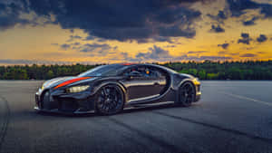 日落時分賽道上帶有橙色條紋的黑色Bugatti Chiron。 — 酷車 壁紙