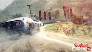 賽事期間，藍色拉力賽車在泥濘森林道路上飄移。 — 電玩遊戲 GIF 壁紙