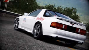 白色日產RX-7賽車在蜿蜒的道路上行駛，背景有樹木。 — 奧迪R8 壁紙