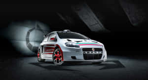 白色 Abarth 拉力賽車，帶有紅色細節，在黑暗的混凝土隧道中被照亮。 — 賽車 壁紙