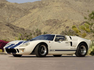 白色福特 GT40 跑車帶有藍色條紋，停泊在沙漠景觀中。 — 福特 壁紙