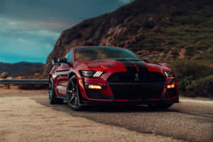 紅色Shelby Mustang GT500在黃昏時停泊在山路上。 — Surface Pro 壁紙