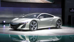 車展上反光舞台上的銀色跑車，聚光燈照射。 — Acura 壁紙