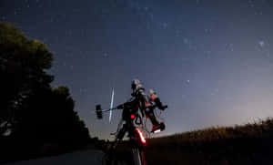 帶紅燈的腳踏車停在鄉村道路上，上方是繁星點點的夜空，有一顆流星。 — 月亮與星星 壁紙