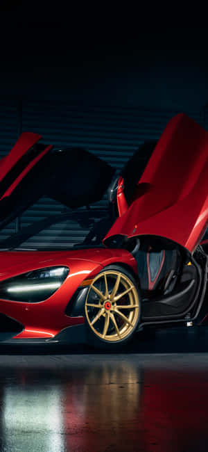 在昏暗車庫中，紅色McLaren跑車配備金色輪圈和打開的車門。 — iPhone 16 Pro 壁紙