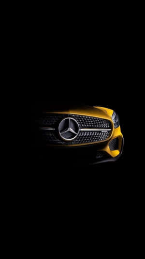 黑暗中發光的黃色 Mercedes-Benz 汽車前格柵。 — Mercedes Amg iPhone 壁紙