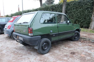 綠色復古Fiat Panda 4x4停泊在碎石上，靠近樹木和樹籬。 — 飛雅特 壁紙