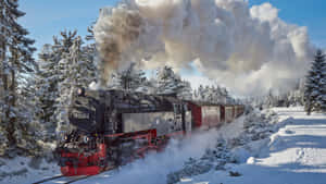蒸汽火車在晴朗的冬日穿過白雪覆蓋的松林 — 霍格華茲 GIF 壁紙