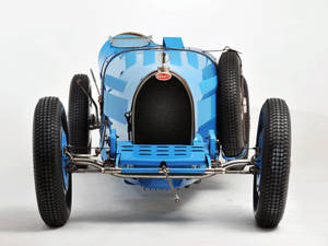 工作室中的復古藍色Bugatti賽車，外露底盤和備用輪胎。 — Bugatti iPhone 壁紙