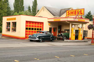 復古青綠色汽車在復古Shell加油站，有黃色油泵和紅色飾邊。 — 加油站 壁紙