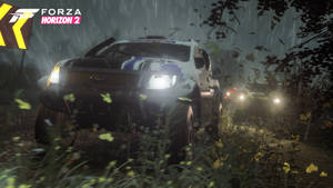 拉力賽車在夜間雨中森林行駛，車頭燈亮起。 — 極限競速 地平線 4 壁紙