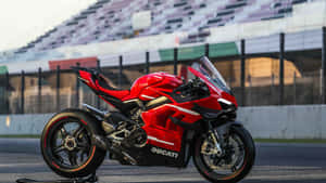 紅色Ducati運動機車在日落時停泊在賽道上。 — 改裝摩托車 壁紙
