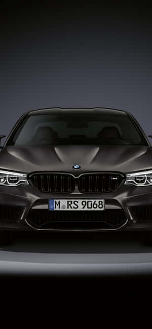 攝影棚燈光下啞光灰色BMW M5的前視圖。 — Galaxy A08 壁紙
