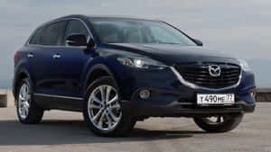 深藍色Mazda CX-9 SUV停放在戶外，背景有山脈。 — 馬自達 壁紙