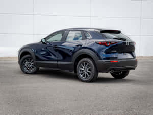 深藍色Mazda CX-30 SUV停泊在白色牆前。 — 馬自達 壁紙