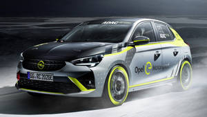 Opel e-Motorsport賽車在夜間濕滑賽道上疾馳，帶有黃色點綴。 — 歐寶 壁紙