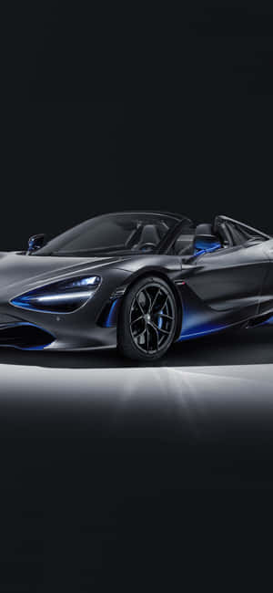 一輛灰色McLaren 720S Spider，在深色反射表面上帶有藍色亮點。 — Redmi Note 14 Pro 壁紙