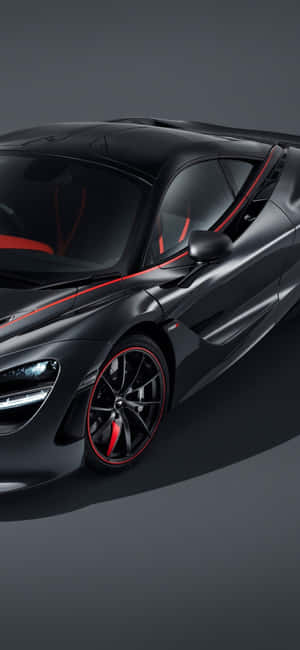 啞光黑色McLaren跑車，帶有紅色飾條和發光的車頭燈，在工作室環境中。 — Samsung S23 壁紙