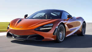 橙色McLaren 720S在賽道上疾馳，駕駛員清晰可見。 — 麥拉倫 720S 壁紙