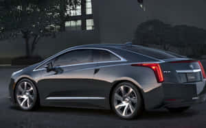深灰色 Cadillac ELR 電動轎跑車在黃昏時停泊於城市環境中。 — Steam Deck 壁紙