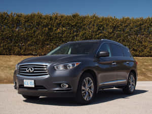 深灰色 Infiniti QX60 SUV 停在戶外，靠近綠色樹籬，在清澈的藍天下。 — 好看汽車 壁紙
