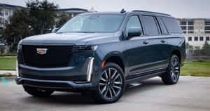 深灰色凱迪拉克 Escalade SUV 停放在公寓大樓前。 — 凱迪拉克 壁紙