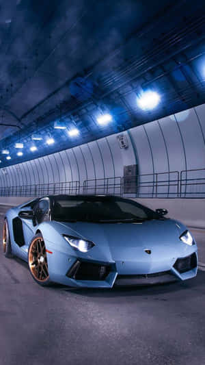 夜間隧道中的淺藍色藍寶堅尼Aventador配金色輪圈。 — 汽車 iPhone 壁紙