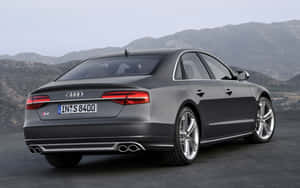 灰色Audi S8轎車停放在道路上，背景有山脈。 — Steam Deck OLED 壁紙