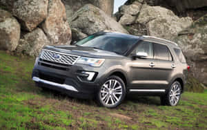 灰色Ford Explorer SUV停放在草地上，靠近大岩石。 — Steam Deck OLED 壁紙