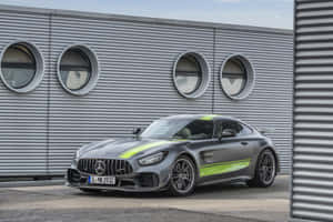 灰色Mercedes-AMG GT跑車，帶有綠色點綴，停在工業建築附近。 — Mercedes Benz C300 壁紙