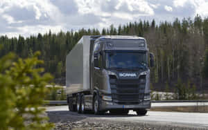 灰色Scania卡車在樹木環繞的道路上行駛。 — 卡車 壁紙