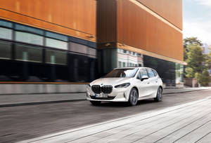白色BMW汽車在現代木質玻璃建築旁飛馳。 — 好看汽車 壁紙