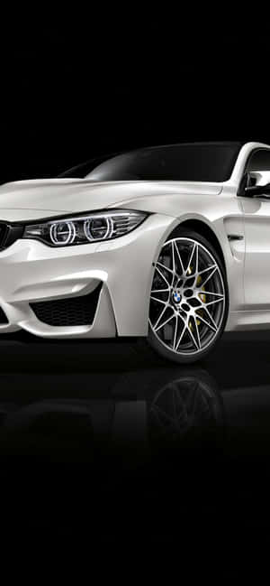 白色BMW跑車，帶金色煞車卡鉗，置於黑色反光表面。 — iPhone 18 壁紙