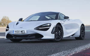 白色McLaren 720S跑車在賽道上，配備黑色輪圈和空氣動力學設計。 — 酷炫F1 壁紙