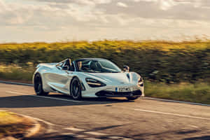 白色McLaren 720S Spider在日落時分行駛在蜿蜒的道路上。 — 汽車 壁紙
