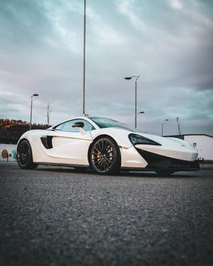 白色McLaren跑車停在瀝青路上，背景陰天。 — 布加迪 GIF 壁紙