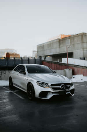 白色Mercedes-AMG停放在積雪的城市停車場。 — Mercedes Benz C300 壁紙