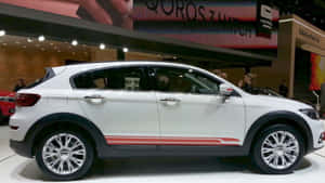 白色Qoros 3掀背SUV，帶有紅色條紋，在車展上展出。 — 好看汽車 壁紙