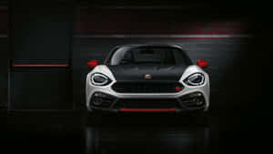 在黑暗車庫中，帶有紅色點綴的時尚白色和黑色Fiat 124 Spider。 — 賽車 壁紙