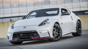 白色日產370Z跑車帶有粉紅色飾邊，停在現代建築附近。 — 日產GTR 壁紙