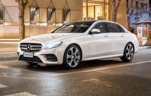 夜間停泊在潮濕城市街道上的白色賓士E-Class轎車。 — Mercedes Benz C300 壁紙