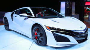 白色跑車，黑色輪圈和紅色制動器在車展上展示。 — Acura 壁紙