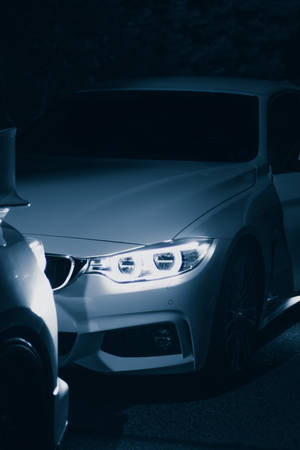 一輛在夜間被車頭燈照亮的白色汽車。 — Mercedes-Benz 壁紙